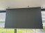 SCREENLINE 108″ motorizuotas projekcinis ekranas, įmontuotas lubose ir nuleistas priešais langus.